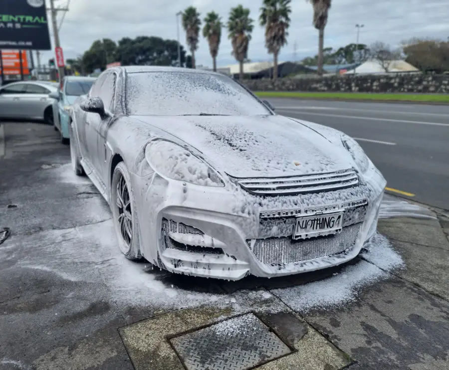 Snow foam pre-wash covering a vehicle before hand washing